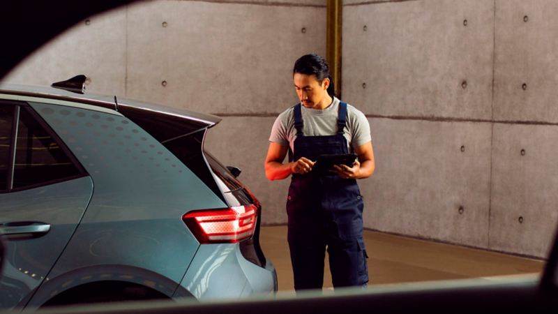 Un agente de servicio de Volkswagen revisando la parte trasera de un Volkswagen ID.3