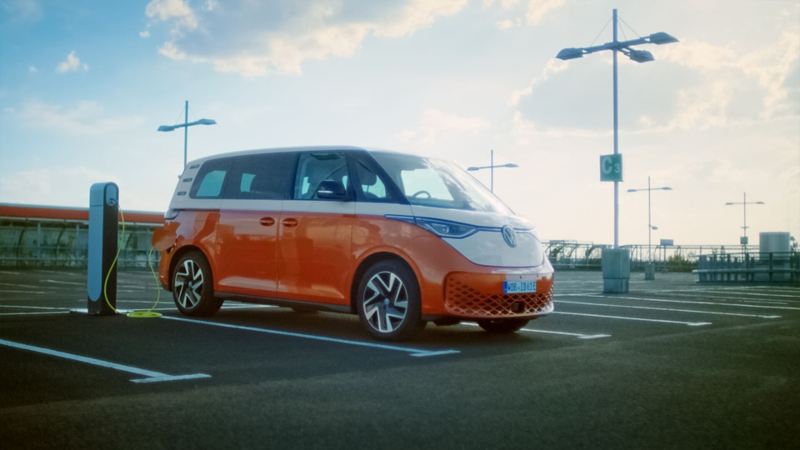 Volkswagen Multivan híbrida eléctrica conectada a una estación de carga en un parking