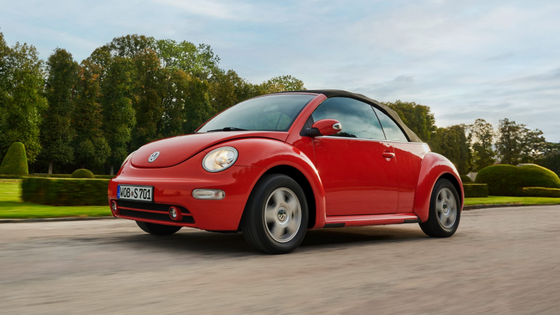 Volkswagen Beetle rojo en un parque con el logo de Approved