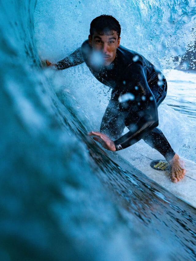 Primer plano de un surfista dentro de una ola con el neopreno The Roadcycled Wetsuit de Blue Banana