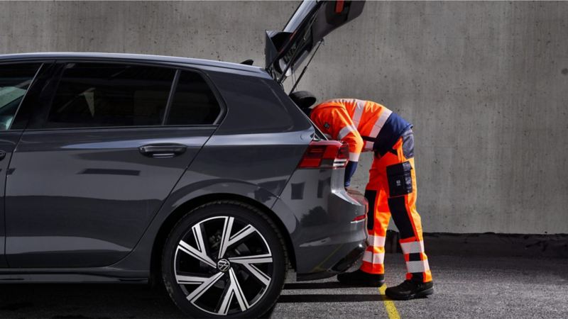 Un agente de servicio Volkswagen revisando el maletero de un coche