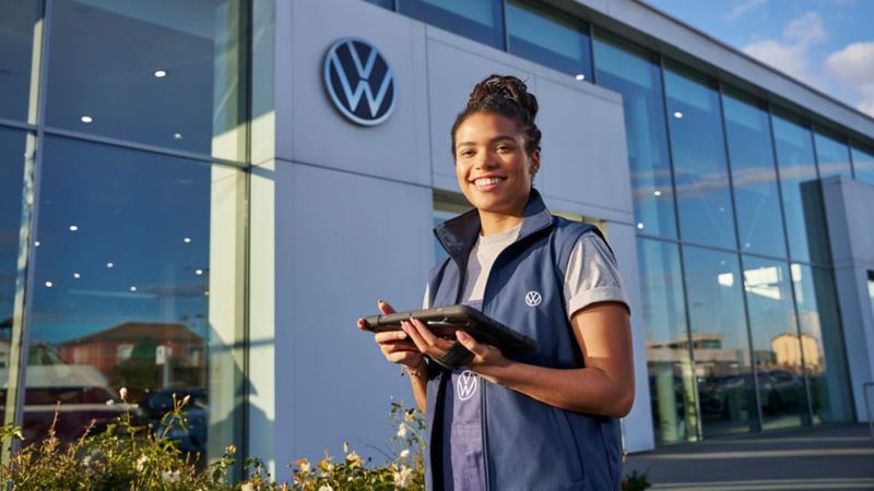 Un profesional del servicio técnico de Volkswagen delante de un concesionario