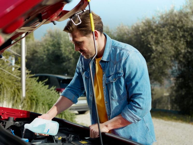 Un chico comprobando el aceite de su Volkswagen