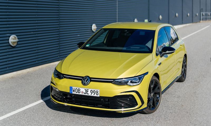 Un Volkswagen de color amarillo circulando por una carretera