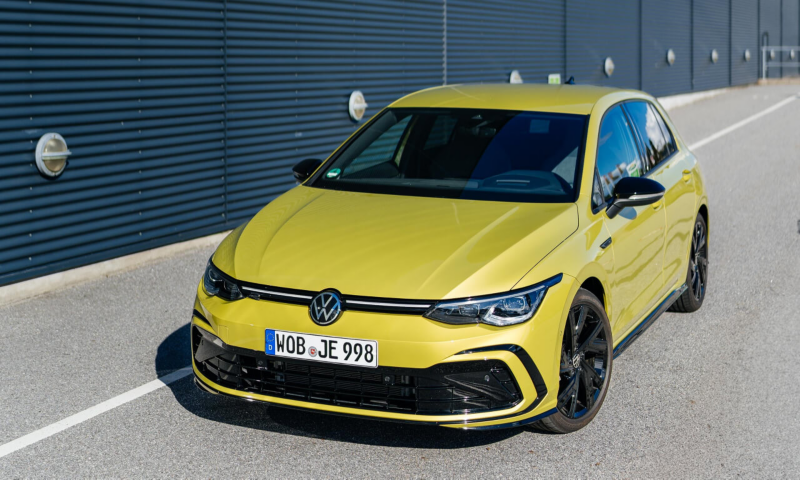 Un Volkswagen de color amarillo circulando por una carretera