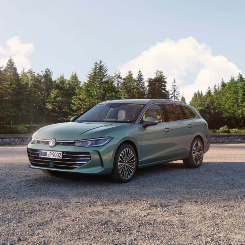 Un Volkswagen Passat verde parado en un camino de tierra con árboles detrás