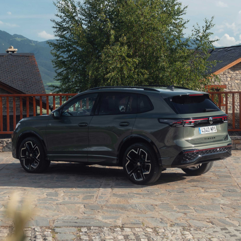 Volkswagen Tiguan verde aparcado en una casa en la montaña