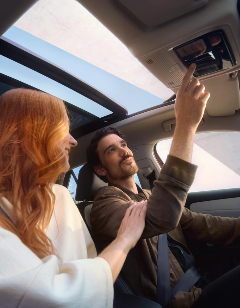 Mujer pelirroja junto a un hombre sentados dentro de un Volkswagen ID.