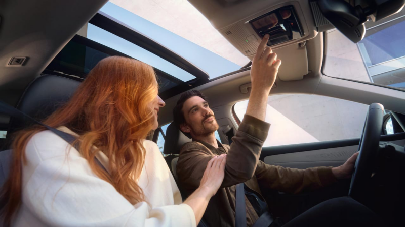 Mujer pelirroja junto a un hombre sentados dentro de un Volkswagen ID.