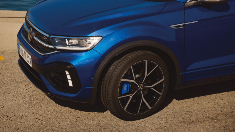 Detalle de la parte delantera de un Volkswagen gama R de color azul estacionado en la calle