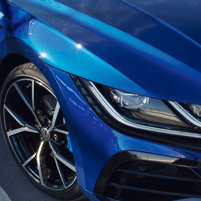Detalle de una llanta y un faro de un Volkswagen Arteon R azul