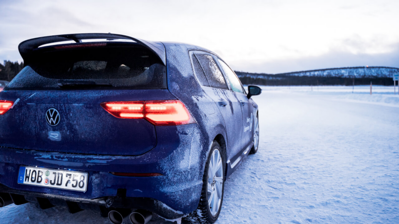 Un Volkswagen R de color azul con la carrocería con hielo estacionado en una pista con nieve