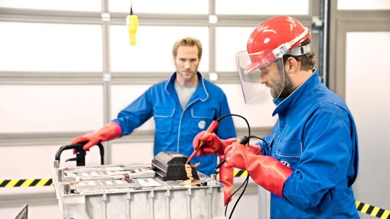 Dos mecánicos revisando una batería de un coche eléctrico