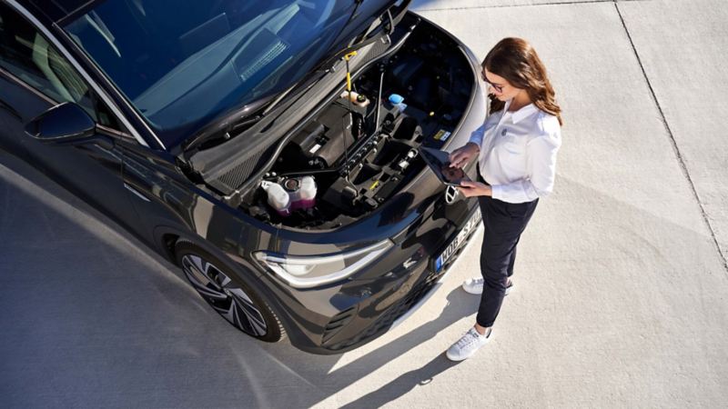 Mujer revisando el motor de un Volkswagen ID.