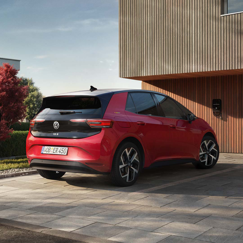 Un Volkswagen ID.3 rojo aparcado frente una casa