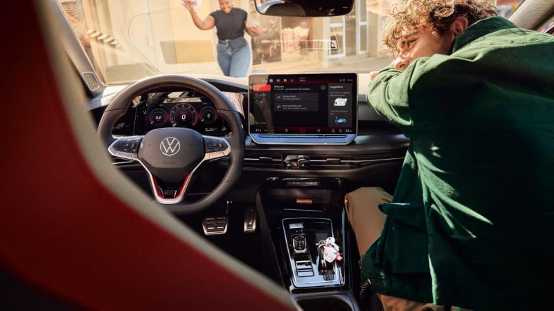 Chico apoyado en el interior de un Volkswagen Golf 50 aniversario