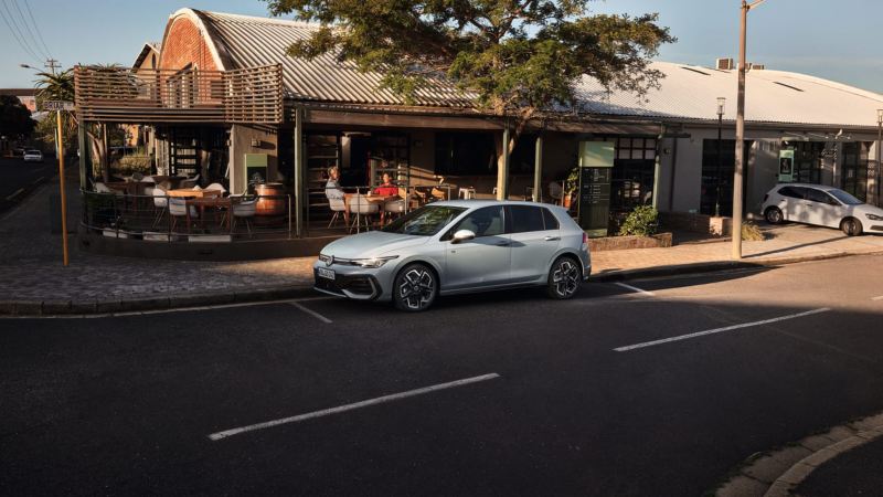 Volkswagen Golf 8 de color gris estacionado en la calle junto a un establecimiento