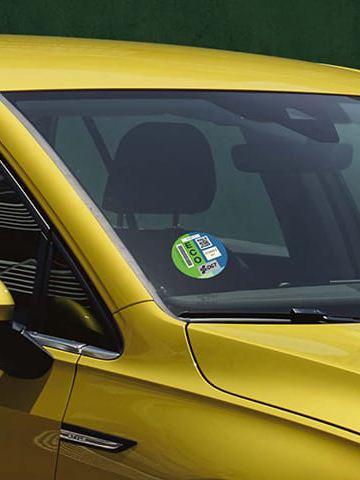 Un Volkswagen Golf 8 amarillo con el sello ECO de la DGT en el parabrisas