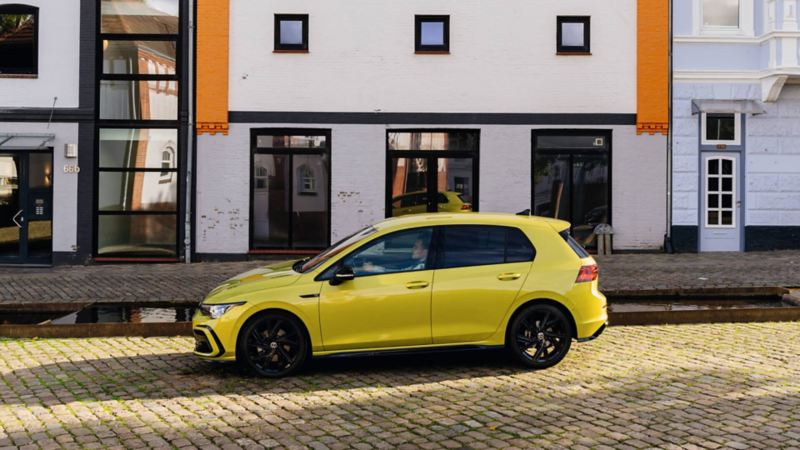 Volkswagen Golf 8 amarillo visto de costado en la ciudad
