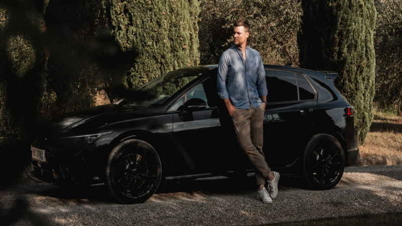 Un chico apoyado sobre un Volkswagen Golf R de color negro