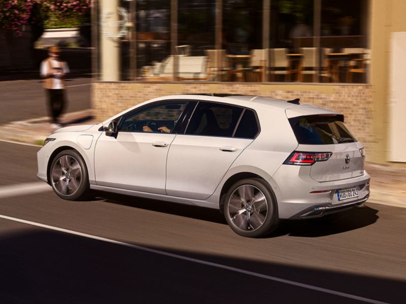 Un Volkswagen Golf de color blanco circulando por la ciudad