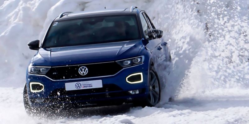 Cliente disfrutando de una experiencia de conducción con un Volkswagen en la nieve.