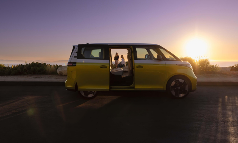 Un Volkswagen ID. Buzz de costado en la playa al atardecer