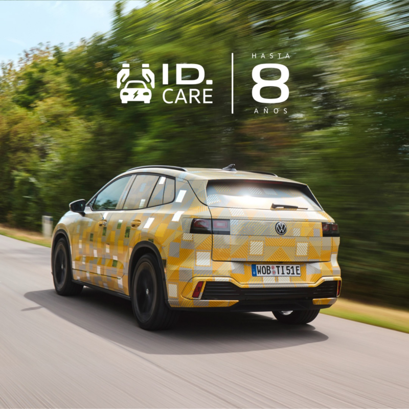 Un Volkswagen ID. Tiguan con camuflaje visto desde atrás en una carretera y el logo de 8 años de ID. Care