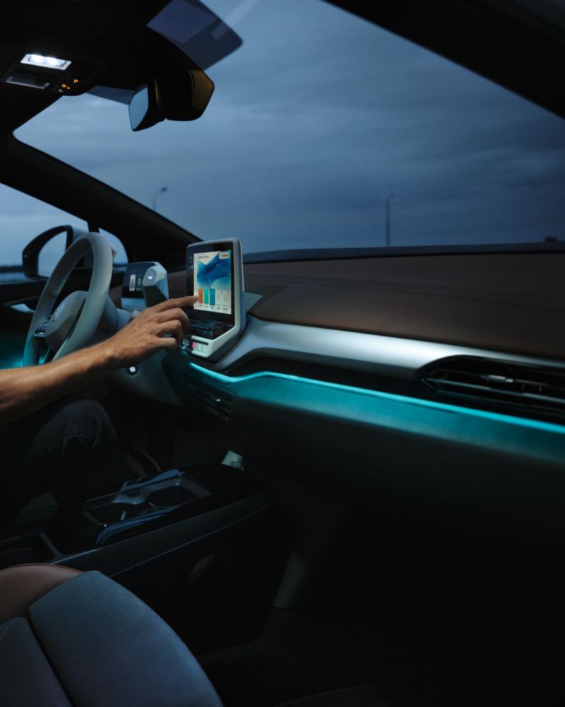 Detalle de un conductor seleccionando la iluminación ambiental en la pantalla de un Volkswagen ID.4