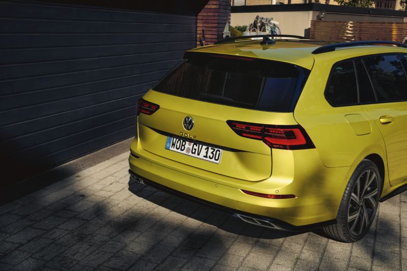 Volkswagen Golf 8 amarillo visto desde atrás aparcado en una casa