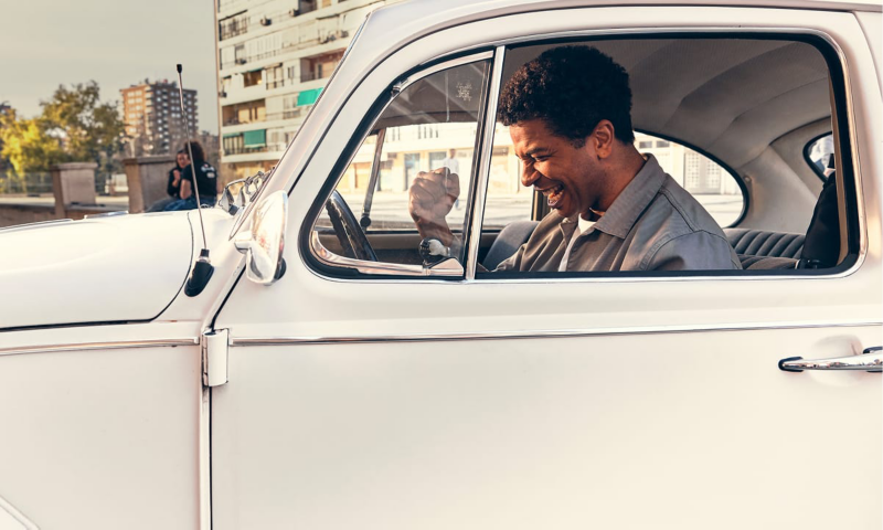 Una persona dentro de un Beetle clásico de Volkswagen celebrando