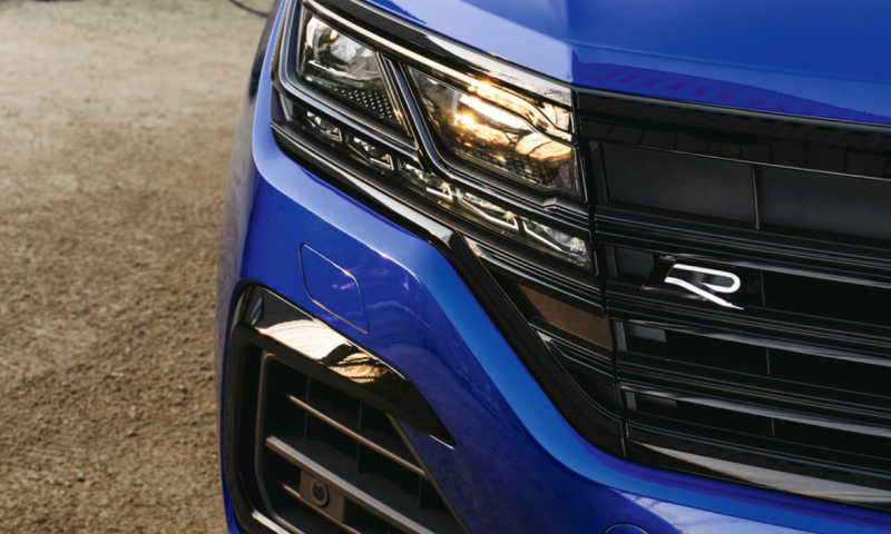 Primer plano el logotipo de Volkswagen R en la parte delantera de un Volkswagen Touareg R azul. 