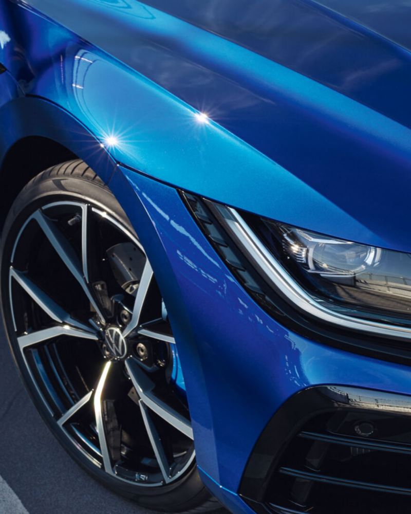 Detalle de una llanta y un faro de un Volkswagen Arteon R azul