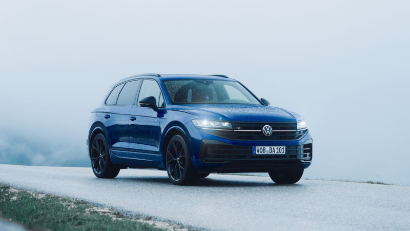 Volkswagen Golf R azul corriendo por una carretera entre montañas.