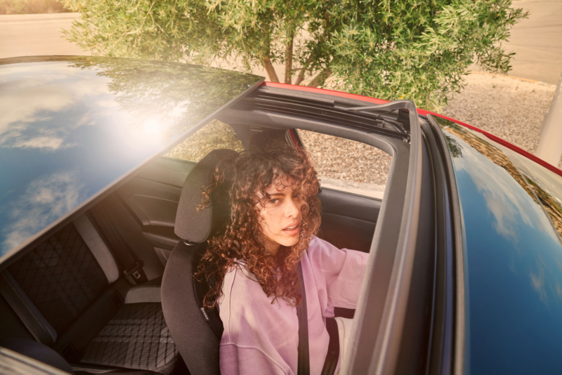Detalle de una chica vista desde la ventanilla superior de un Volkswagen Taigo