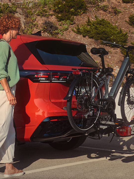 Una pareja poniendo una bicicleta en un Volkswagen de color rojo