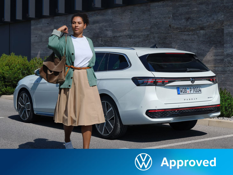 Una mujer al lado de un Volkswagen Passat de color blanco estacionado en la calle