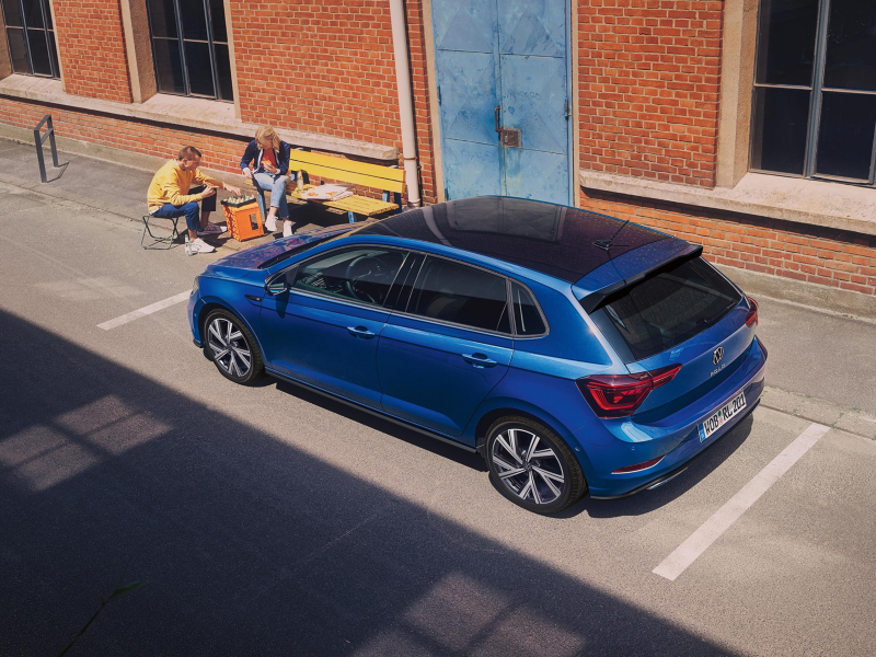 Un Volkswagen Polo de color azul oscuro estacionado en una placa de aparcamiento