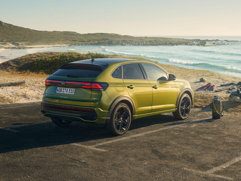 Un Volkswagen Taigo de color verde aparcado frente a la playa