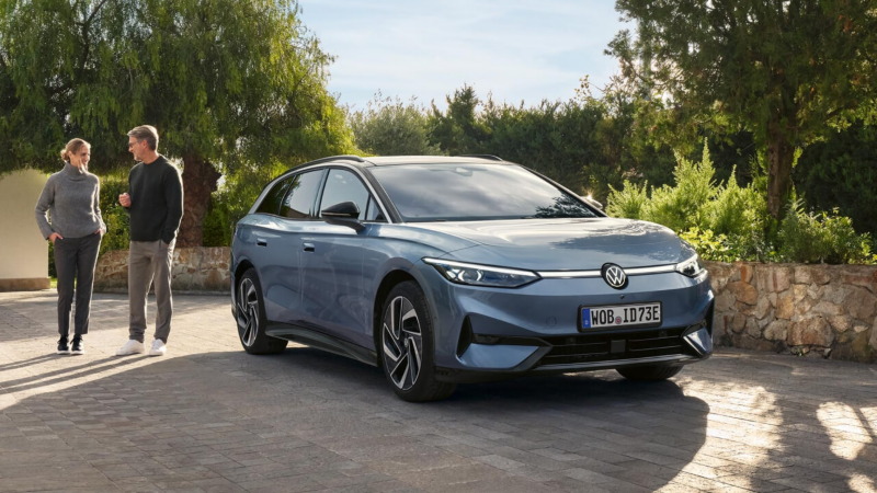 Una pareja al lado de un Volkswagen ID.7 Tourer de color gris estacionado en la calle