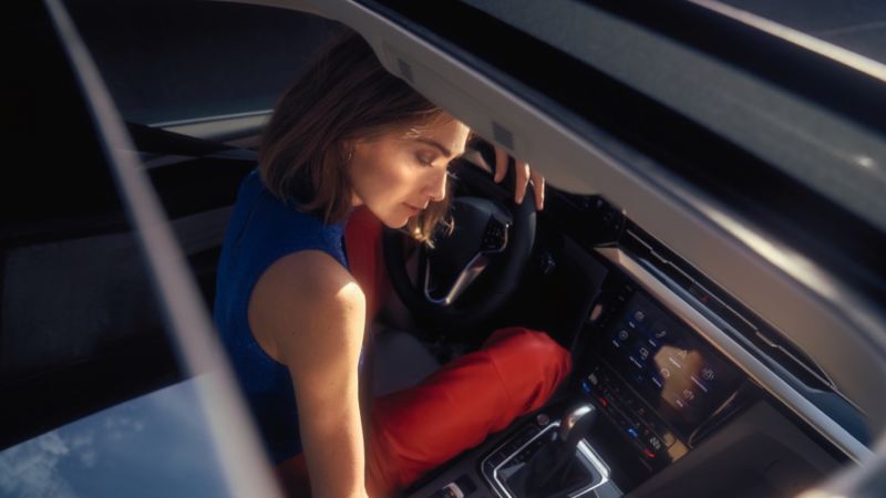 Chica entrando en un Nuevo Volkswagen Arteon vista desde la ventanilla del acompañante
