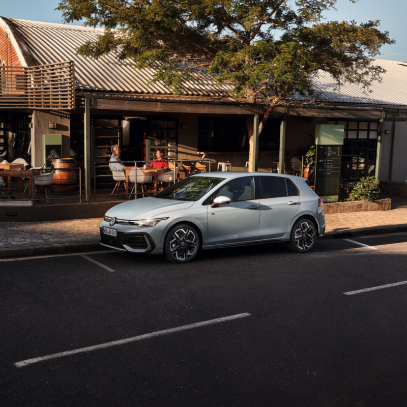 Volkswagen Golf 8 de color gris estacionado al lado de un establecimiento