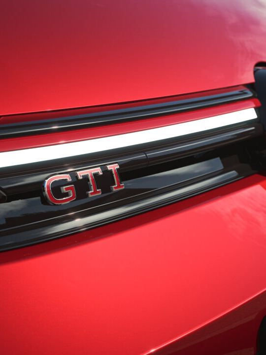 Detalle de la parte delantera del coche de un Volkswagen GTI de color rojo