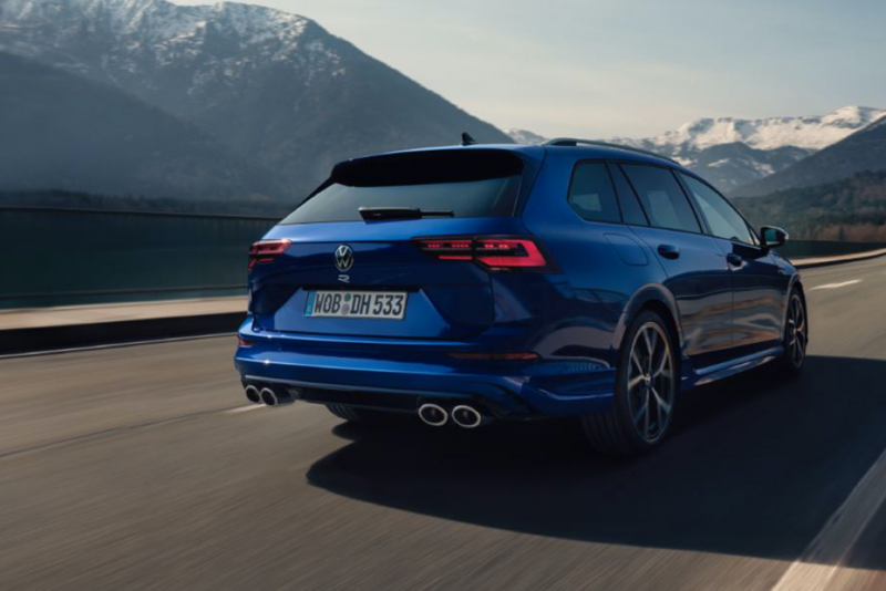 Volkswagen Golf 8 Variant R azul visto desde atrás en una carretera con montañas de fondo