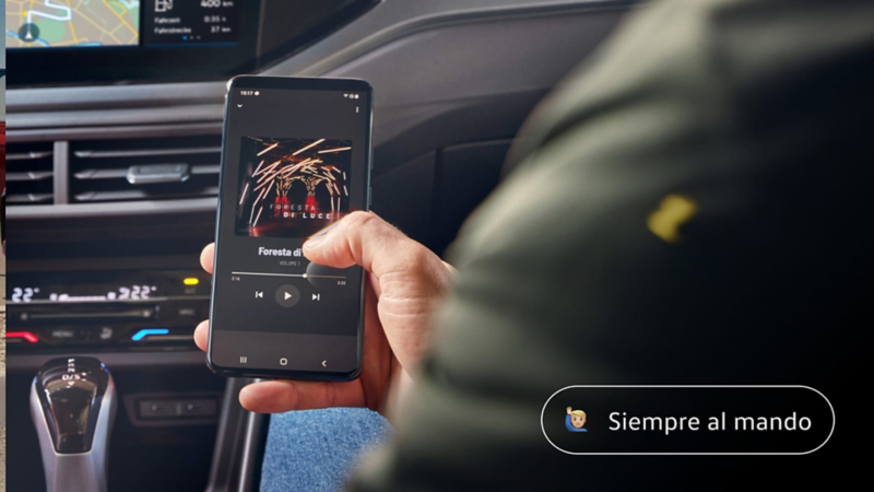 Detalle de una mano con un móvil y el salpicadero de un Tiguan 20 aniversario
