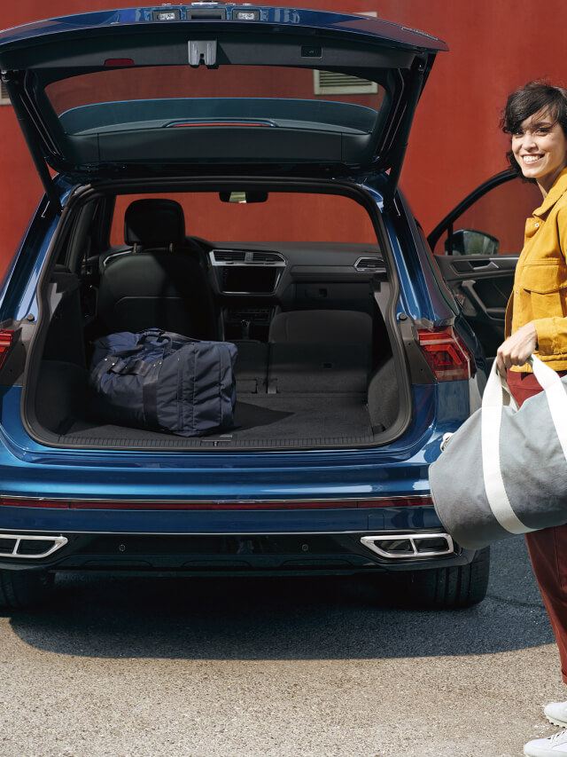 Chica cargando una bolsa en el maletero del Volkswagen Tiguan