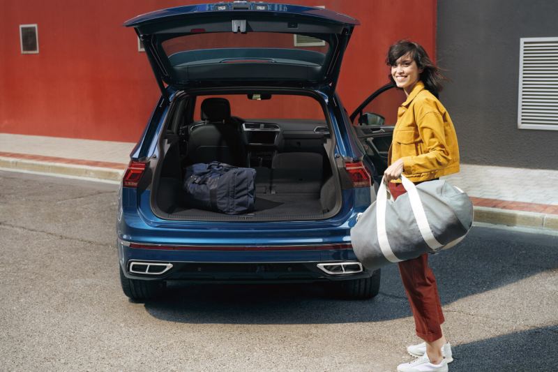 Chica cargando una bolsa en el maletero del Volkswagen Tiguan
