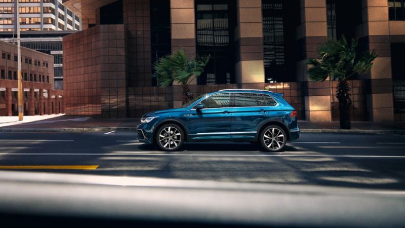 Volkswagen Tiguan azul metalizado visto de costado circulando por la ciudad