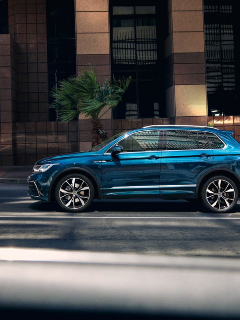 Volkswagen Tiguan azul metalizado visto de costado circulando por la ciudad