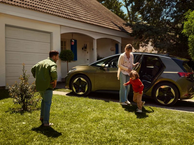 Una familia junto a un Volkswagen ID. 3 aparcado en casa
